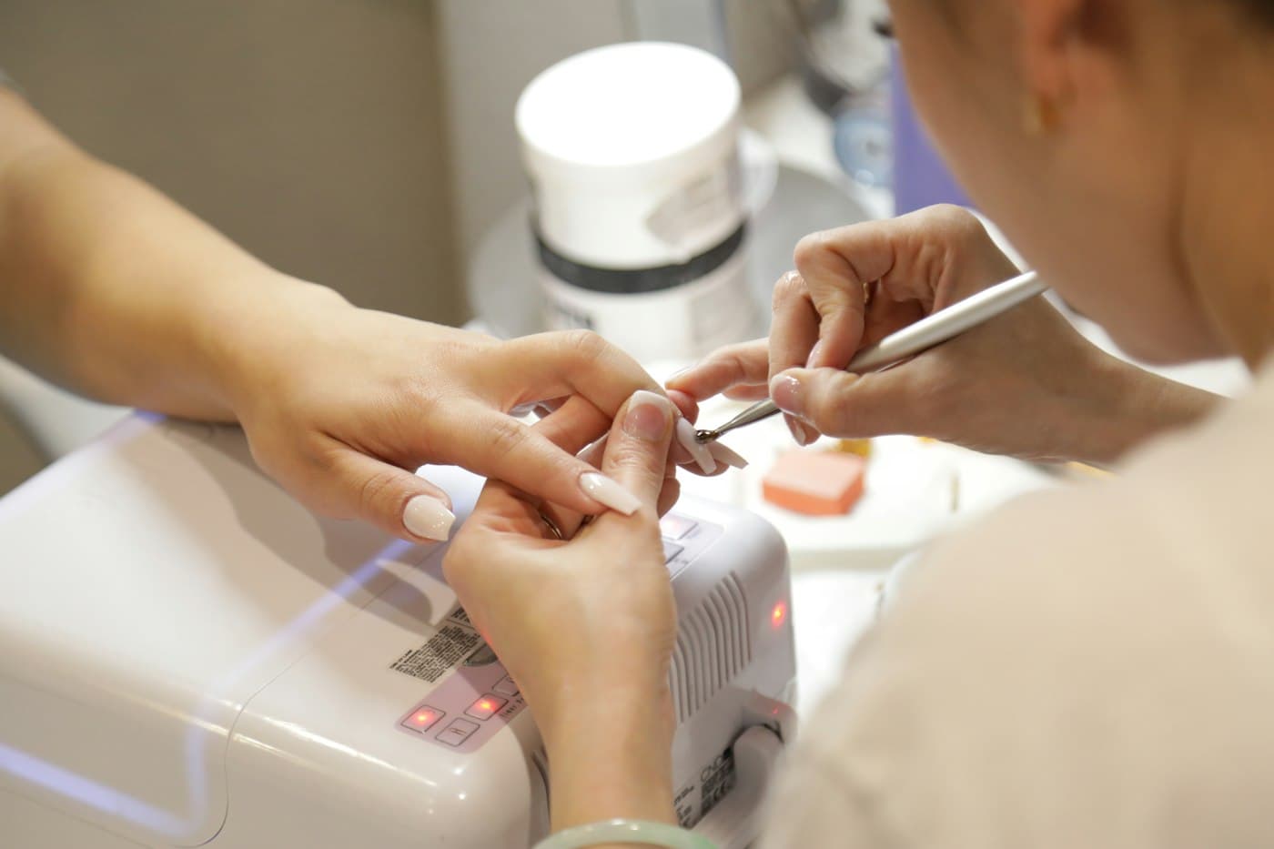 Nail technician working on a customer's nails in a salon
